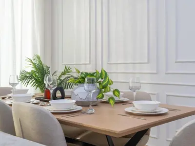 a wooden table with glasses and plates and plants at Burj Views 3 min from Dubai Mall Luxury DownTown Residence in Dubai