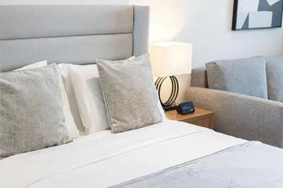 a bed with pillows and a lamp on a table at New Studio in Business Bay with private Jacuzzi in Dubai