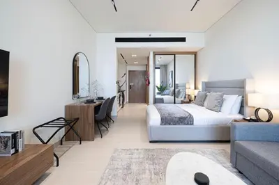 a bedroom with a bed and a living room at New Studio in Business Bay with private Jacuzzi in Dubai
