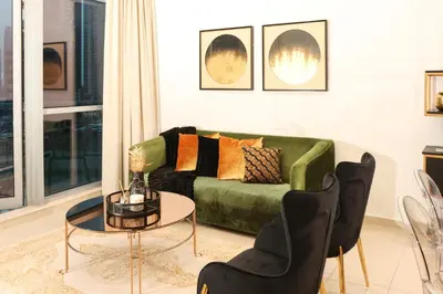 a living room with a green couch and chairs at Full Marina view, mins to JBR beach, Ain Dubai, Palm in Dubai