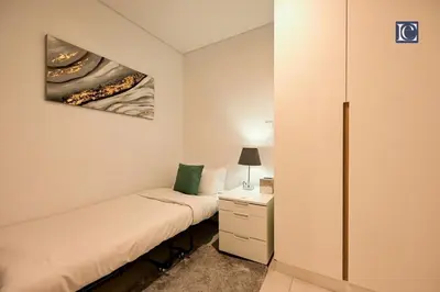 a small bedroom with a bed and a dresser at Luxury Escapes - Exquisite 3BR plus Maid, Full Sea View in JBR in Dubai