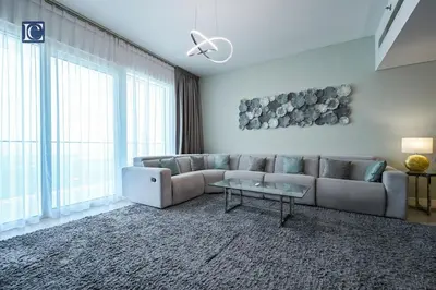 a living room with a couch and a table at Luxury Escapes - Exquisite 3BR plus Maid, Full Sea View in JBR in Dubai