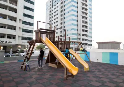 a group of people playing on a playground at 1Bedroom Apartment with Portable bed in Living Area in Dubai
