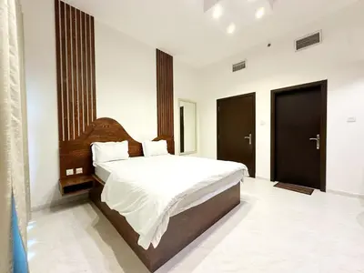 a bedroom with a large bed with white sheets at 1Bedroom Apartment with Portable bed in Living Area in Dubai