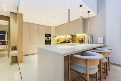 a kitchen with a large island with stools at Family Beach Home 3BR on Palm Jumeirah with Pool in Dubai