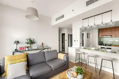 a living room with a couch and a kitchen at Dubai Marina Luxury 2BR with Pool, Gym & Near JBR Beach, Metro in Dubai