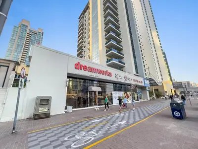 a store on a street with people walking their dogs at Dubai Marina Luxury 2BR with Pool, Gym & Near JBR Beach, Metro in Dubai