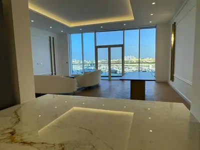 a living room with a table and a large window at 5 Star Luxury 3BR Apartment on The Palm with Huge Pool and Beach in Dubai