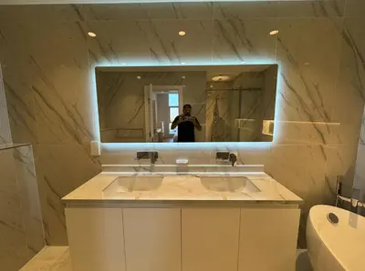 a person taking a picture in a bathroom mirror at 5 Star Luxury 3BR Apartment on The Palm with Huge Pool and Beach in Dubai