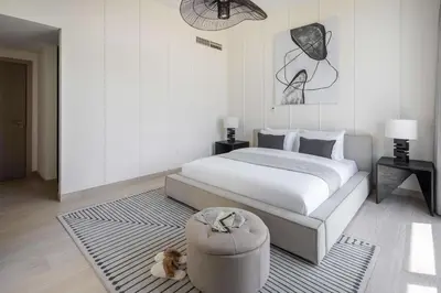 a bedroom with a large bed and a ottoman at Frank Porter - Murooj Al Furjan West in Dubai