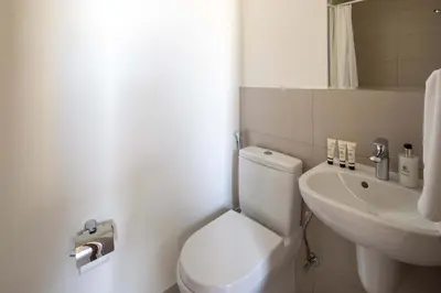 a white bathroom with a toilet and a sink at Frank Porter - Murooj Al Furjan West in Dubai