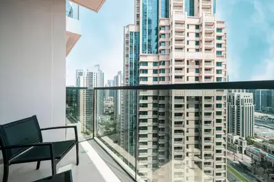a balcony with a chair and a view of a city at Act One Act Two - Close to Dubai Mall & Burj Khalifa - Downtown Dubai - Luxury Apartments by Canvas Holiday Homes in Dubai