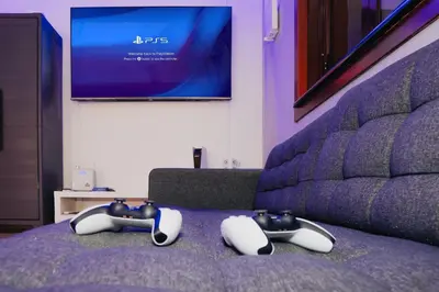 two video game controllers sitting on top of a bed at Berloga Holiday Homes JBR in Dubai