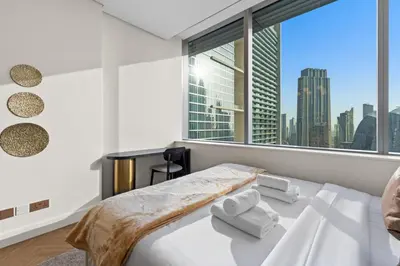 a bedroom with a bed and a large window at Luxury Apt DIFC, XL Layout, Pool, Gym, Skyline View in Dubai