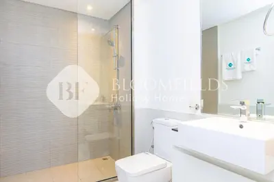 a bathroom with a shower and a toilet and a sink at Bloomfields 1br Elegant Escape The Pulse in Dubai