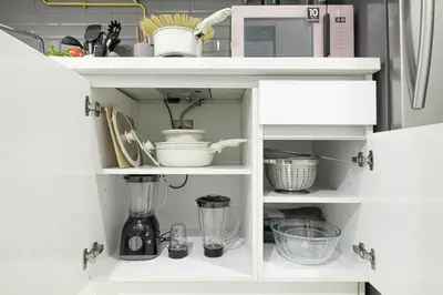 a kitchen cabinet filled with lots of kitchen utensils at Cozy Studio 7 Minutes From Dubai Mail in Dubai