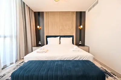 a bedroom with a large bed with a blue blanket at Relax in Style 2BR Huge Terrace Lagoon Access in Dubai