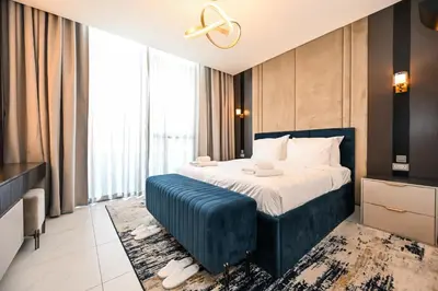 a bedroom with a bed and a large window at Relax in Style 2BR Huge Terrace Lagoon Access in Dubai
