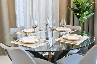 a dining room table with plates and wine glasses at Relax in Style 2BR Huge Terrace Lagoon Access in Dubai