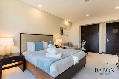 a bedroom with a large bed with blue and white sheets at The Prestige in Dubai