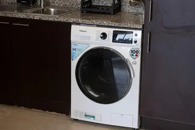 a white washing machine in a kitchen next to a sink at King Bed & Modern Comfort Studio in DIFC Downtown in Dubai