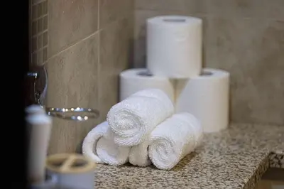 a pile of towels on a counter in a bathroom at King Bed & Modern Comfort Studio in DIFC Downtown in Dubai