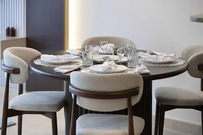 a table with chairs and plates and glasses on it at King Bed & Modern Comfort Studio in DIFC Downtown in Dubai