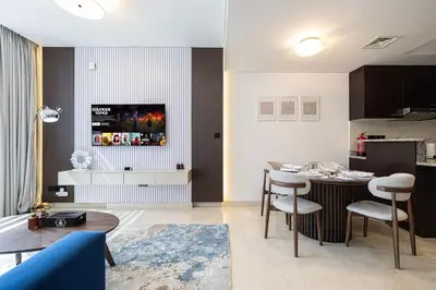 a kitchen and a living room with a table and chairs at King Bed & Modern Comfort Studio in DIFC Downtown in Dubai