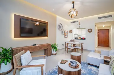 a living room with a couch and a tv on the wall at Oasis by Tarrab in Dubai