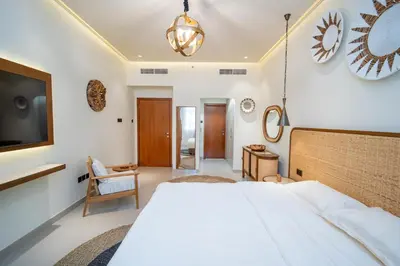 a bedroom with a large white bed and a tv at Oasis by Tarrab in Dubai