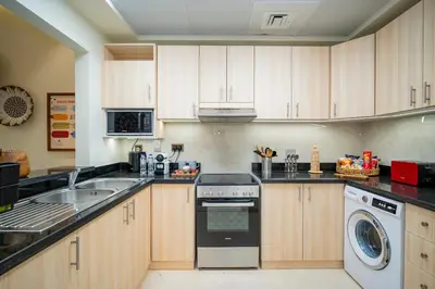 a kitchen with a sink and a dishwasher at Oasis by Tarrab in Dubai