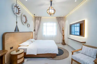 a bedroom with a bed and a couch and a tv at Oasis by Tarrab in Dubai