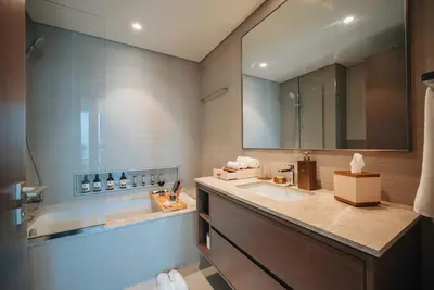 a bathroom with a sink and a tub and a mirror at Stylish 2-Bedroom Luxury Stay in Downtown Dubai with Burj Khalifa & Fountain Views in Dubai
