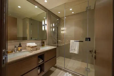 a bathroom with a sink and a glass shower at Stylish 2-Bedroom Luxury Stay in Downtown Dubai with Burj Khalifa & Fountain Views in Dubai