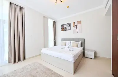 a white bedroom with a bed and a window at Scala Tower- Business Bay Dubai - Luxury Apartments by Canvas Holiday Homes in Dubai