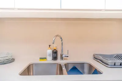 a kitchen sink with two bottles on it at Escape24 Elegant 2BR with Canal view near Safa Park in Dubai