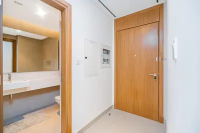 a bathroom with a wooden door and a sink at Escape24 Elegant 2BR with Canal view near Safa Park in Dubai
