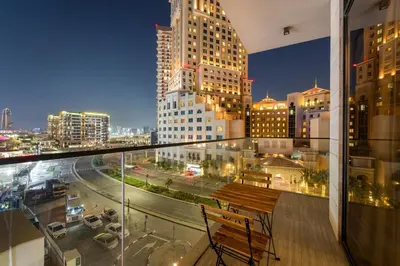 a balcony with a bench and a city at night at Chic 2BR Close to Burj Khalifa, Dubai Mall & Creek in Dubai