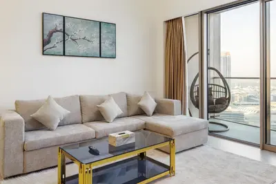 a living room with a couch and a glass table at Grande 2BR Apartment with Burj Khalifa & Fountain Views in Dubai