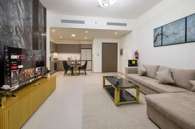 a living room with a couch and a flat screen tv at Grande 2BR Apartment with Burj Khalifa & Fountain Views in Dubai