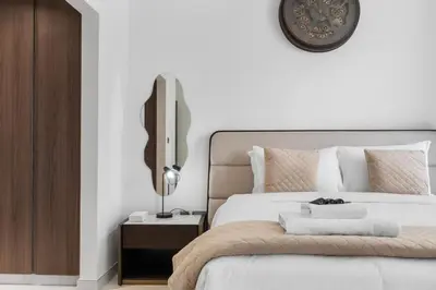 a bedroom with a bed and a clock on the wall at Luxurious 1 BR in District One Beach Access in Dubai