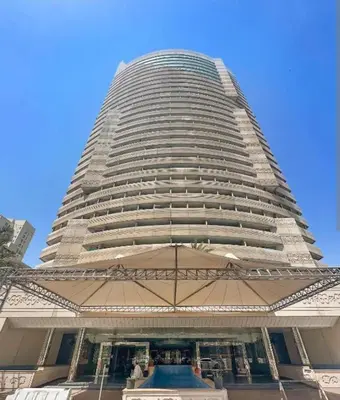 a tall building with a pool in front of it at Luxury Apartment- 5 min Walking Distance Beach and 3 minutes walking distance Metro in Dubai