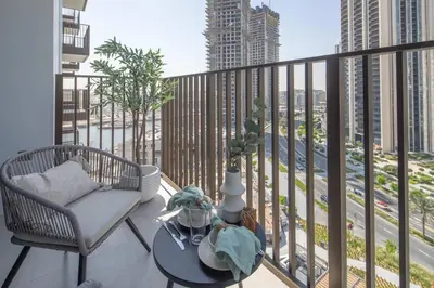 a balcony with a chair and a table at Frank Porter - Creek Crescent Tower 1 in Dubai