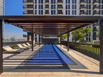 a large pool with blue tiles on the floor of a building at Frank Porter - Creek Crescent Tower 1 in Dubai