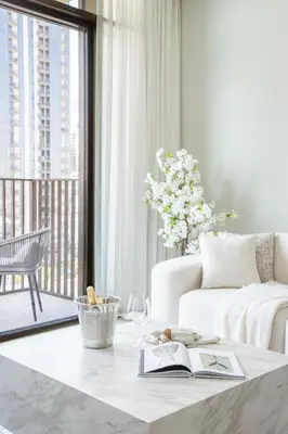 a living room with a couch and a table with a book at Frank Porter - Creek Crescent Tower 1 in Dubai