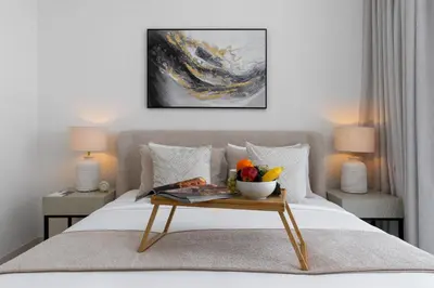 a bed with a table with a bowl of fruit on it at Maison Privee - Coastal Living with Uninterrupted Sea & Palm Views in Dubai
