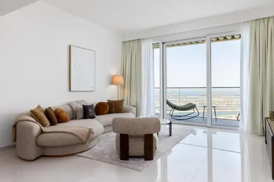 a living room with a couch and a chair at Maison Privee - Coastal Living with Uninterrupted Sea & Palm Views in Dubai