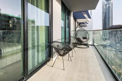 two chairs sitting on the balcony of a building at Luxury 1BR JVC Pool & Balcony by Circle Mall in Dubai