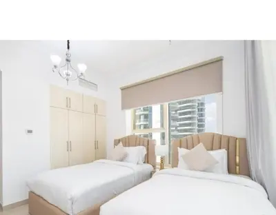 two beds in a white room with a window at Dubai Marina-2Bedroom-3 balcony with view-direct acces to Marina Promenade in Dubai