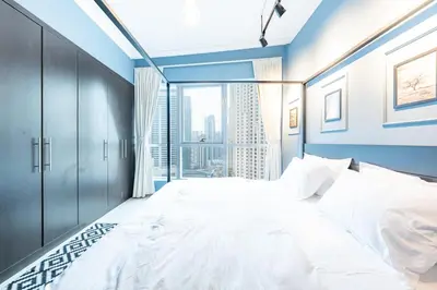a bedroom with a large bed with a large window at Charming Stay by Dubai Marina in Dubai